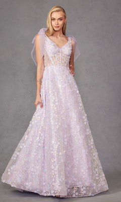 A woman poses gracefully against a plain gray background wearing the Lilac Purple Long Lace Prom Dress: Juliet JT2439K, featuring a sheer bodice, floral embellishments, and sheer shoulder bows.