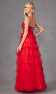 A woman wears the Juliet JT2451S Long Ruffled Prom Ball Gown, featuring a sleeveless red tulle design with a tiered, ruffled skirt, as she poses against a gray background, looking over her shoulder.