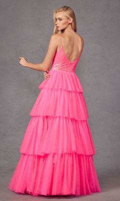 A woman models the Long Prom Dress JT2457H by Juliet—a fuchsia ruffle tulle ball gown with spaghetti straps and a sequin bodice—standing against a gray background, facing away with her head turned to the side.