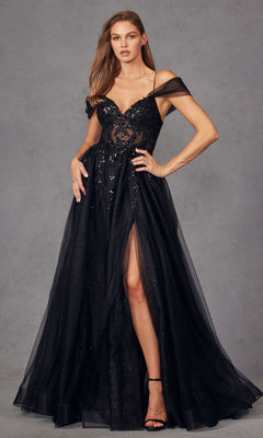 A woman wears the Sheer-Waist Long Prom Ball Gown: Juliet JT2466A, a black, off-the-shoulder dress with a sheer bodice, sequin accents, and thigh-high slit, standing against a gray background.