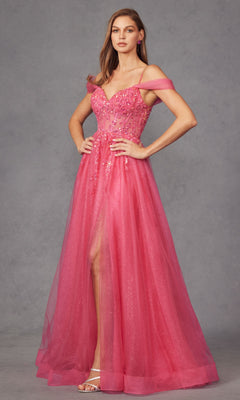 A woman poses against a plain gray background, wearing the Sheer-Waist Long Prom Ball Gown: Juliet JT2466A—an off-the-shoulder pink dress featuring floral embellishments and a sheer overlay.