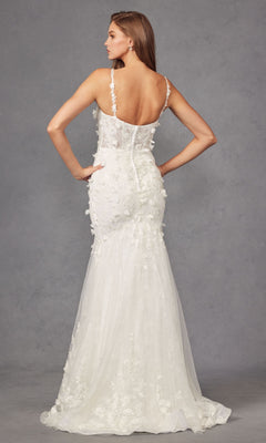 A woman stands facing away in the Long Prom Dress JT2475UW by Juliet, featuring an off-white mermaid silhouette with floral appliqués, thin straps, a low back, and an elegant train.