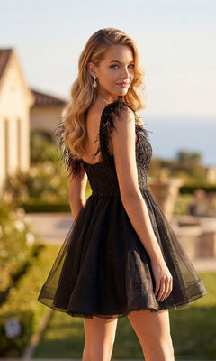 A woman with long, wavy blonde hair wears the Juliet JT881 short homecoming dress, featuring feathered shoulder details and a touch of tulle, as she stands outdoors looking over her shoulder.