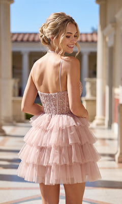 Wearing the Sheer-Corset Short Ruffled Hoco Dress JT923S—a light pink, tiered tulle A-line dress with thin straps—a woman stands outdoors, smiling with a classical building in the background.
