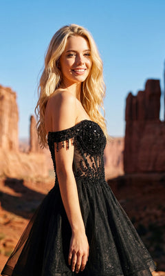 A woman with long blonde hair, wearing the Short Champagne Corset Prom Dress: Juliet JT947L, stands outdoors in a rocky desert landscape, smiling at the camera.
