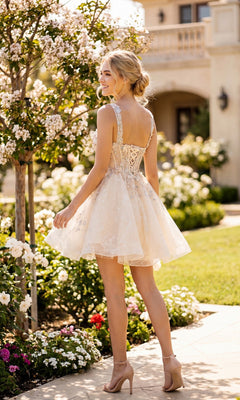 A woman stands in a garden, smiling as she faces away, wearing the Juliet JT976L Short Pastel A-Line Hoco Dress with delicate lace.