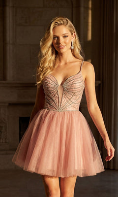 A woman indoors near sunlit windows wears the Sheer-Corset Short Hoco Dress: Juliet JT984S—a sleeveless, blush pink fit-and-flare homecoming dress with a beaded v-neck corset bodice.