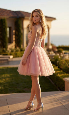A woman stands outdoors on a sunny day, wearing the Sheer-Corset Short Hoco Dress: Juliet JT984S in pink with silver heels, with a house and greenery in the background.