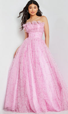 A woman wearing the Jovani 26209 long prom dress—a strapless, floor-length pink ball gown with ruffle neckline detail and floral patterns—stands against a light-colored background.