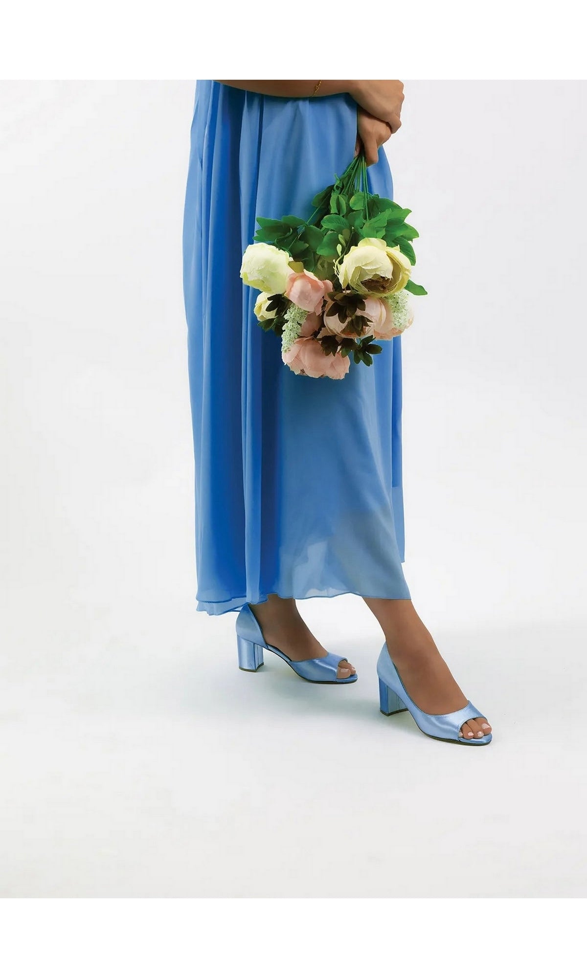 Person wearing a blue dress and light blue Joy White Block Heel Prom Shoes: Dyeables 4375 peep toe block heel pumps, holding a bouquet of flowers.