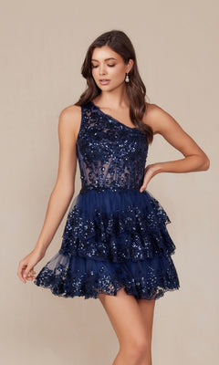 A woman models the One-Shoulder Short Sequin Homecoming Dress K855, a navy blue dress featuring ruffled layers and elegant embellishments, while standing against a plain background.