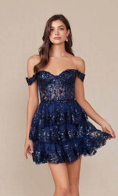 A woman models the Off-Shoulder Short Ruffled Sequin Hoco Dress K856—a navy blue, sequined, short tiered style with a sheer bodice—while standing against a neutral background.