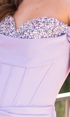 Close-up of the Off-the-Shoulder Corset Prom Dress: Katrina by Velvi in lavender, featuring pearl embellishments along the top edge and visible seam detailing.