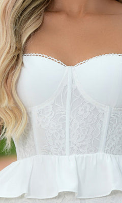 Close-up of a woman wearing the Kiara Short White Ruffled Graduation Party Dress, featuring a strapless lace corset top with a ruffled hem and an A-line skirt for an elegant, feminine look.