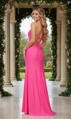 A woman stands outdoors between greenery-adorned columns wearing the La Femme Strappy-Back Long Jersey Prom Dress in bright pink.