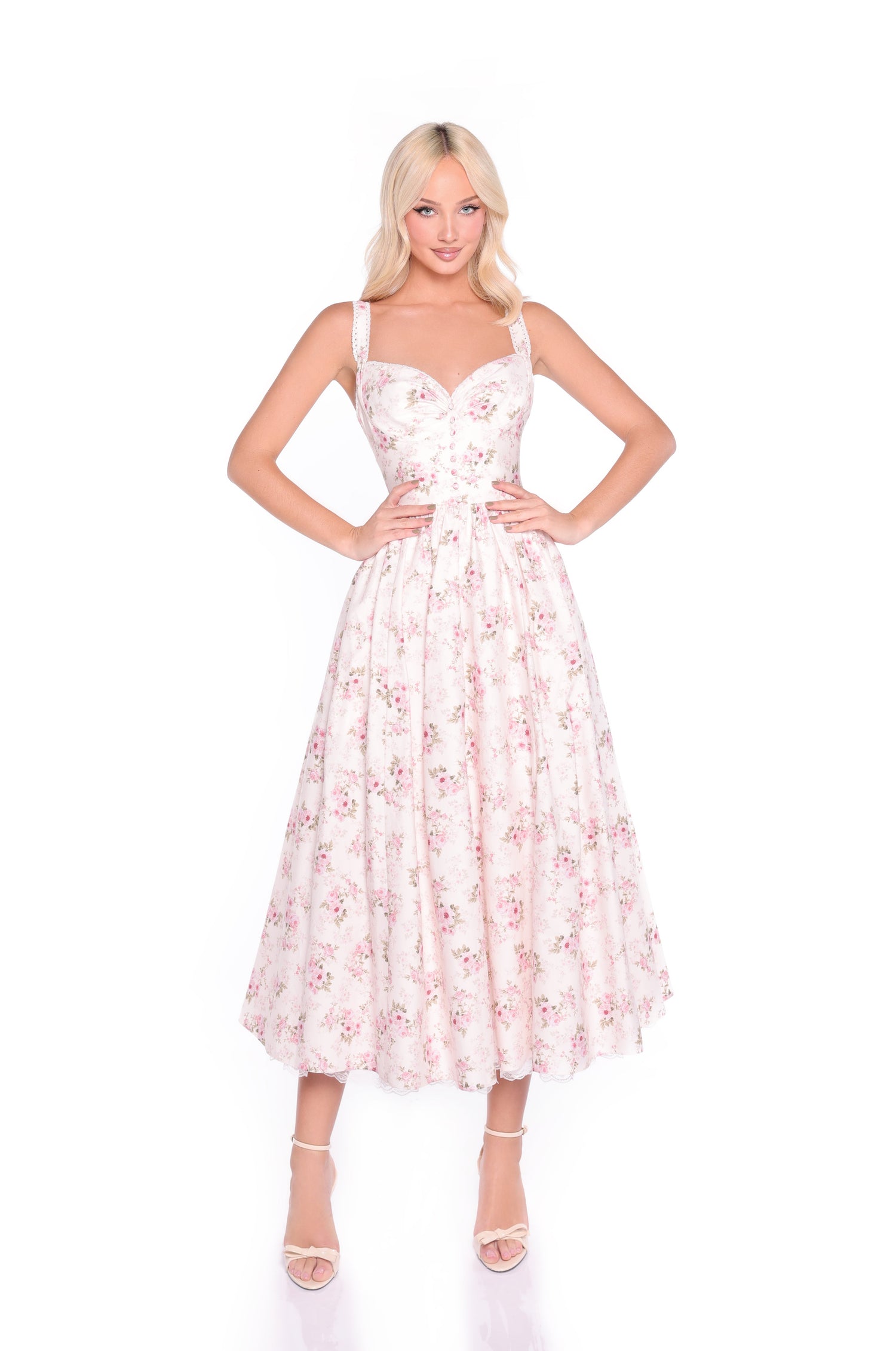 A woman models the Cream Floral Print Casual Midi Dress: Liora, featuring a fitted bodice and flared midi skirt, styled with strappy heels against a white background.