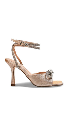 Lux Champagne Stiletto Prom Shoes: Touch Ups 4742 in a champagne-colored glittery stiletto sandal with a rhinestone-embellished ankle strap and a crystal heart ornament at the toe.