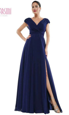 A woman models the Marsoni M251, a navy long formal dress with a V-neckline, cap sleeves, and a high leg slit, standing against a white background.