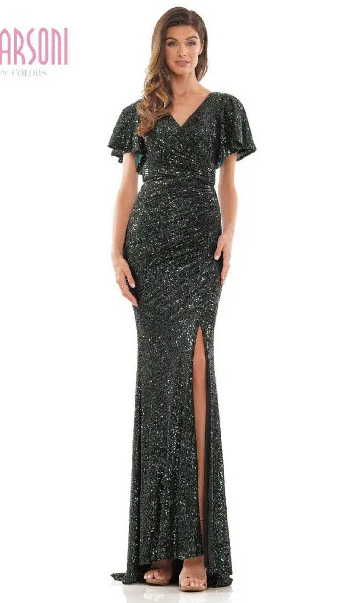 A woman stands against a plain background wearing the Marsoni M318 long formal dress in deep green, featuring sequins, short flutter sleeves, a v-neckline, and a front leg slit.