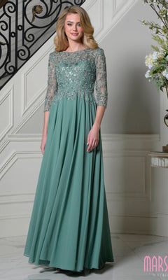 A woman stands indoors wearing the Long Formal Dress: Marsoni M340SL in sage, featuring a beaded-embroidered bodice, sheer three-quarter sleeves, and a graceful a-line chiffon skirt.