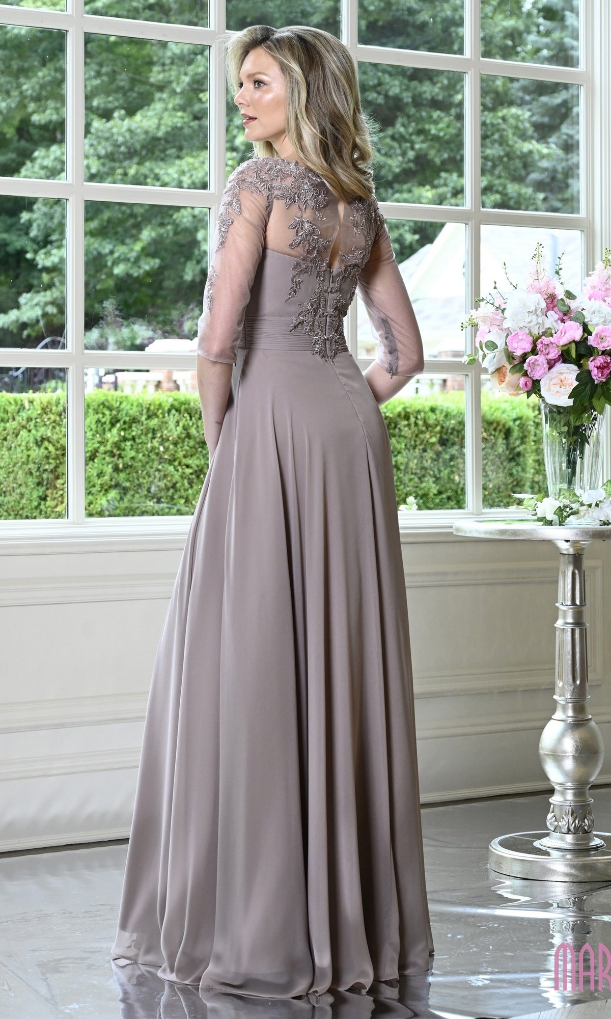 A woman wears a mauve, floor-length chiffon Modest Formal Dress: Marsoni M357 with sheer, embroidered three-quarter sleeves and a high neckline.
