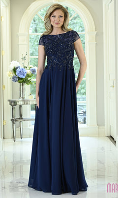 A woman wearing a Modest Long Formal Dress: Marsoni M360 in navy blue, featuring a floor-length A-line skirt, a beaded bodice, and cap sleeves.