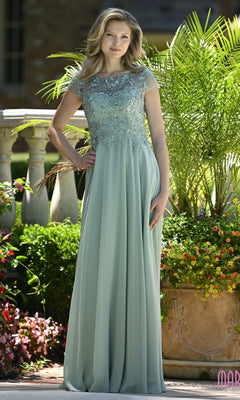 A woman stands outdoors wearing a sage Modest Long Formal Dress: Marsoni M360, featuring a short-sleeved bodice and a long, flowing A-line skirt.