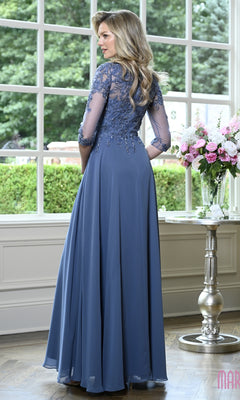 A woman wearing a slate blue Modest Formal Dress: Marsoni M361 with sleeves, an embroidered bodice, and a floor-length skirt with lace detailing.