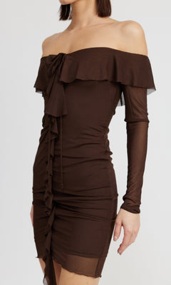A woman wears the Chocolate Brown Short Party Dress with Sleeves—an off-the-shoulder style featuring long sleeves and ruffle details on the neckline and front.