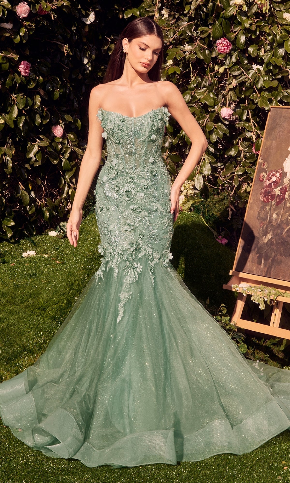 A woman stands elegantly in the Andrea & Leo MA101, a long sleeve formal dress with a beaded lace bodice and a graceful mermaid skirt trailing behind her.