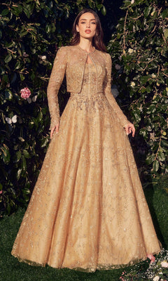 A woman stands outdoors in the Andrea & Leo MA104, a long sleeve formal dress with a matching jacket, surrounded by greenery and flowers.