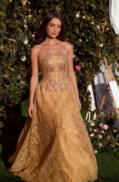 A woman wearing the Andrea & Leo MA104 long sleeve long formal dress stands outdoors near greenery and flowers, with an easel and candles in the background.