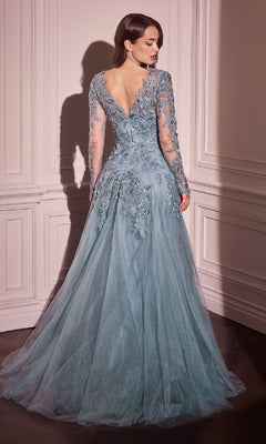 A woman stands facing a white paneled wall, wearing the Andrea & Leo MA108 long sleeve long formal gown in light blue tulle with lace appliques and floral embroidery.
