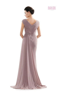 A woman stands facing away against a white background, wearing the Marsoni MV1080 Long Formal Dress—a mauve chiffon evening gown with draped fabric and a v-shaped back.