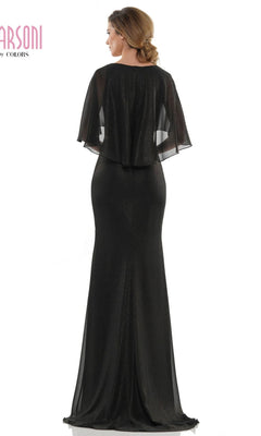 A woman stands with her back to the camera in the Marsoni MV1130 long formal dress, featuring a fitted sheath silhouette and a sheer cape-style overlay.