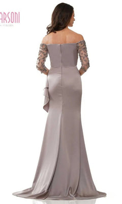 A woman faces away from the camera in a Marsoni MV1254 long formal dress—an off-shoulder, floor-length mauve gown with sheer beaded sleeves and a fitted bodice.