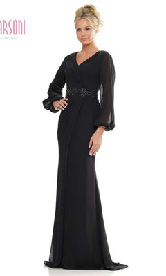 A woman models the Marsoni MV1273 long formal dress in black, featuring sheer long sleeves, a V-neckline, and beaded details at the waist and shoulders, set against a plain white background.