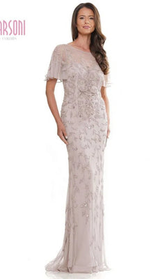 A woman models the Marsoni MV1281 long formal dress in champagne, featuring a floor-length skirt, sheer short sleeves, an illusion sweetheart neckline, and intricate bead embroidery, against a plain white backdrop.