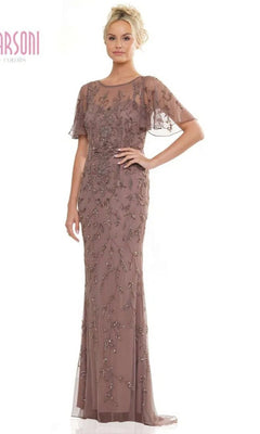 A woman models the Marsoni MV1281 long formal dress in dark taupe, featuring sheer short sleeves, intricate beadwork, and an illusion sweetheart neckline on a floor-length gown.
