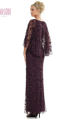A woman stands facing away, wearing the Marsoni MV1282 long formal dress in dark purple, featuring floral embroidery, beaded leaf appliques, and a sheer capelet.