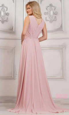 A woman stands in an elegant room wearing the Marsoni MV1292, a light pink, floor-length chiffon formal dress with a sleeveless design, V-shaped back, and beaded waist embellishments.