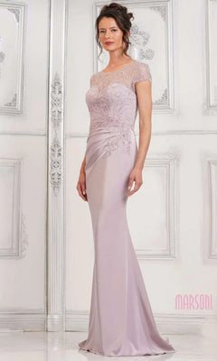 A woman models the Marsoni MV1317 long formal dress in dusty rose, featuring a sheath skirt, delicate lace detailing, and short sleeves against an elegant white background.