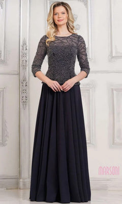 A woman poses in front of a white ornate wall wearing the Marsoni MV1319 Long Formal Dress in Midnight, featuring a beaded bodice, three-quarter sleeves, and a flowing A-line skirt.