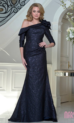 A woman in the Marsoni MV1399 long formal dress in navy, featuring jacquard fabric and a floral shoulder accent, stands elegantly by a staircase in an opulent interior.