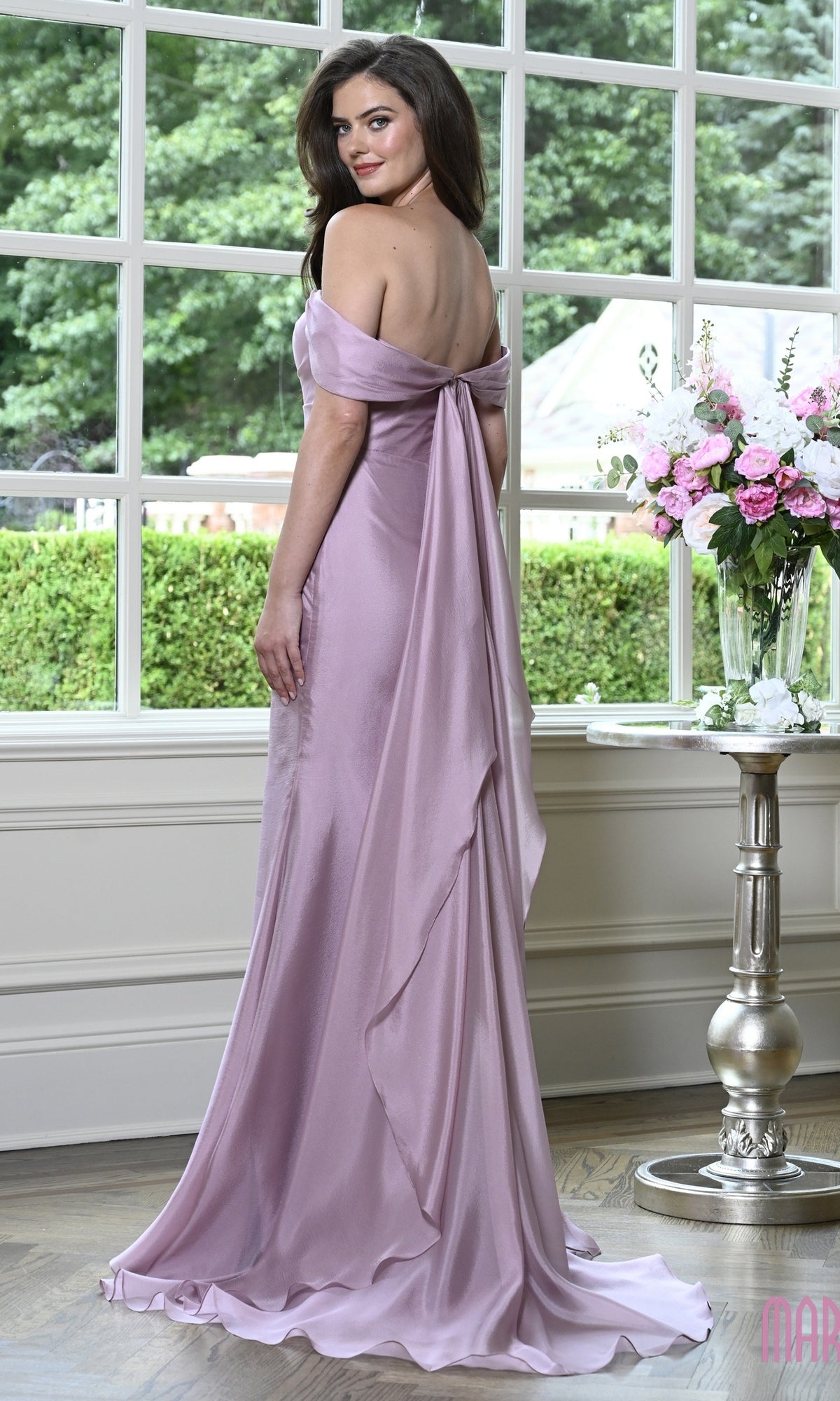 A woman wearing a mauve off-the-shoulder Long Formal Dress: Marsoni MV1424, featuring a sweetheart bodice, draped back, chiffon fabric, and a train.