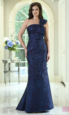 A woman in a navy Marsoni MV1429 long formal dress, featuring a one-shoulder evening gown design with a shimmering botanical pattern and a knot detail on the bodice.