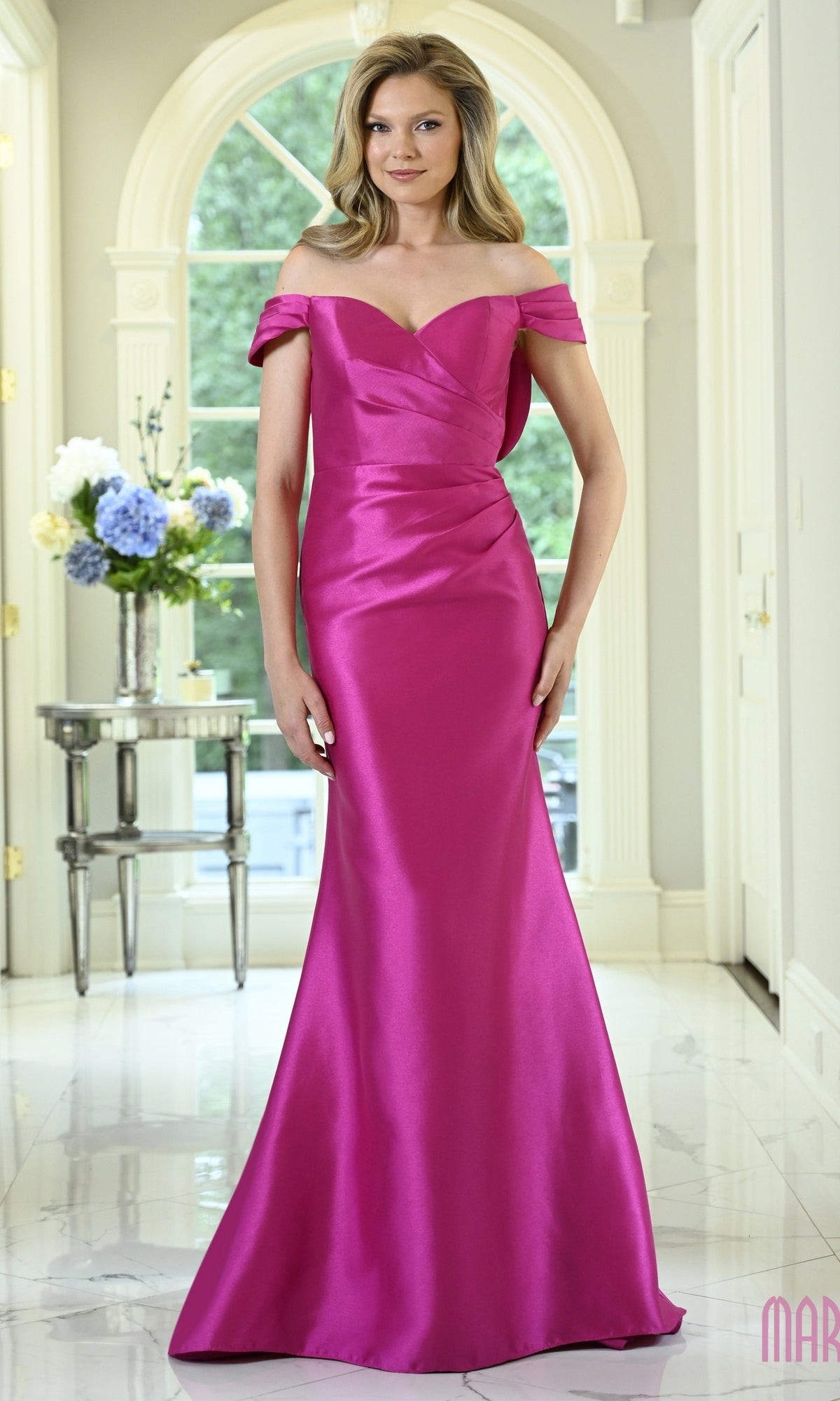 A woman wearing a fuchsia Marsoni MV1434 off-the-shoulder floor-length gown with a sweetheart neckline and a fitted silhouette.