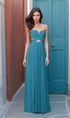 A woman wearing the La Femme Strapless A-Line Designer Prom Dress 22230, a teal evening gown with a waist cutout, stands before a teal door and reddish-brown wall.