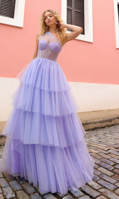 A woman stands on a cobblestone street in front of a pink and white building, wearing the Sheer-Bodice Long Layered Prom Ball Gown P1400.