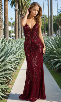 Woman in a burgundy evening gown standing on a path with palm trees in the background